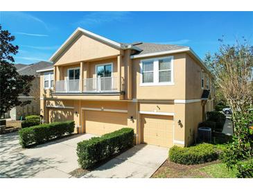 Two-story townhome showcasing its charming architecture, private balconies, and manicured landscaping, under a clear, sunny sky at 10876 Eclipse Lily Way # 60, Orlando, FL 32832