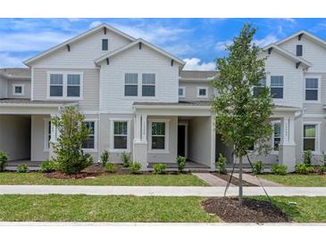 Charming townhome with light gray exterior, landscaped front yard, and covered entryway at 13809 Luna Harvest Ave, Winter Garden, FL 34787