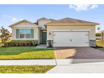 Charming single-story home with a well-manicured lawn and a brick paver driveway leading to a two-car garage at 1452 Hopedale Pl, Sanford, FL 32771