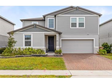 Charming two-story home with brick driveway, landscaped yard, and attached two-car garage at 261 Whistling Duck Trl, St Cloud, FL 34771