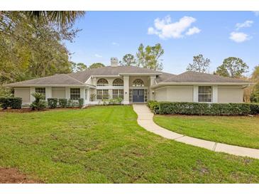 Expansive single-story home with well-manicured lawn, lush landscaping, and a welcoming walkway to the front door at 2991 Timpana Pt, Longwood, FL 32779