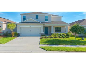 Charming two-story home featuring a well-manicured lawn and attached two-car garage at 5709 Sagunto Dr, Davenport, FL 33897