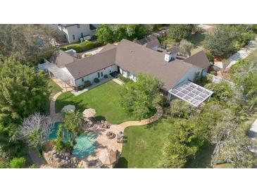 Expansive aerial view of a single-story home showcasing the pool, large yard and outdoor living space at 8244 Oakland Pl, Orlando, FL 32819