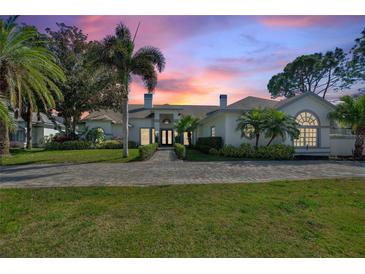 Stunning home with lush landscaping, inviting entryway, and brick paver driveway, perfect for luxurious living at 8606 Summerville Pl, Orlando, FL 32819