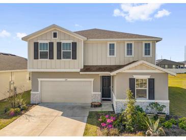 Charming two-story home with a two-car garage, well-maintained lawn, and complemented by colorful flowers at 1209 Mattie Pointe Blvd, Auburndale, FL 33823
