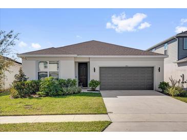 Charming single-story home featuring a well-manicured lawn and an attached two-car garage at 1773 Groveline Rd, St Cloud, FL 34771