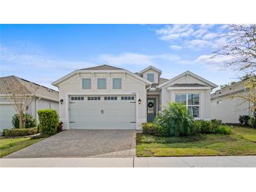 Charming single-story home featuring a two-car garage and beautifully landscaped front yard at 2087 Flora Pass Pl, Kissimmee, FL 34747