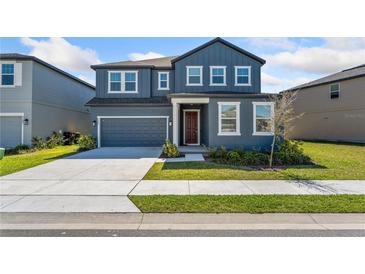 Charming two-story home with a well-manicured lawn and attached two-car garage at 2099 Derwent Dr, Davenport, FL 33896