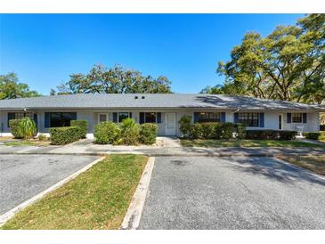 Charming townhome exterior featuring manicured landscaping, blue shutters, and convenient parking at 2723 Beacon St, Eustis, FL 32726