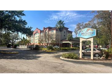 An inviting exterior view of the Galleria Palms Hotel under a partly cloudy bright blue sky at 3000 Maingate Ln # 227, Kissimmee, FL 34747
