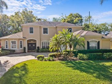 Inviting two-story home boasting a manicured lawn, lush landscaping, and a paver driveway at 5325 Cypress Reserve Pl, Winter Park, FL 32792