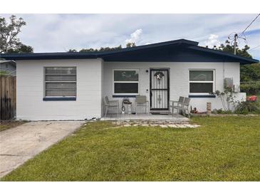 Charming single-story home featuring a well-maintained lawn and a cozy front porch with chairs at 655 Katherine Ave, Orlando, FL 32810