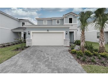Charming two-story home featuring a two-car garage, lush landscaping and a welcoming front entrance at 7376 Oakmoss Loop, Davenport, FL 33837