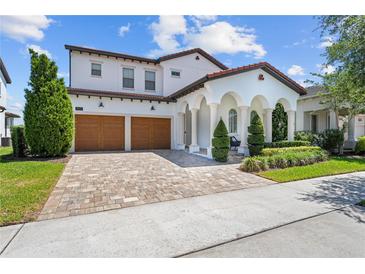 Stunning two-story home with a brick driveway, arched entryway, and a two-car garage at 8025 Topsail Pl, Winter Garden, FL 34787