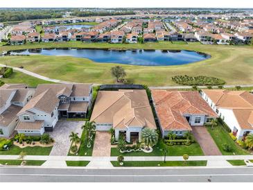 A beautiful aerial view shows the tile roofs and backyard lake views of this luxury home at 13346 Alderley Dr, Orlando, FL 32832