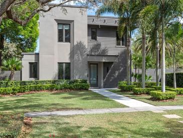 Striking modern home with well-maintained lawn, lush landscaping, and a stylish gray facade at 1970 Laurel Rd, Winter Park, FL 32789