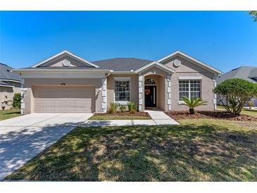 Charming single-story home featuring a manicured lawn and inviting facade at 2487 Ridgemoor Dr, Orlando, FL 32828