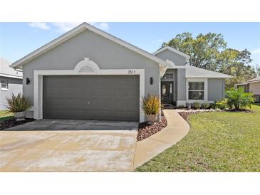 Charming single-story home with a two-car garage, well-manicured lawn, and inviting front entrance at 2511 Chatham Cir, Kissimmee, FL 34746