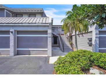 Charming townhome featuring a garage, private entry staircase, and mature landscaping at 5122 Cypress Creek Dr # 103, Orlando, FL 32811