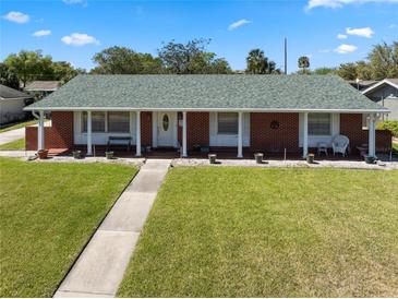 Charming single-story home featuring a brick facade, white columns, and a well-manicured lawn, offering great curb appeal at 812 Arlington Blvd, Altamonte Springs, FL 32701
