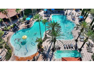 Aerial view of a vibrant resort pool area with palm trees, lounge chairs and water features at 12544 Floridays Resort Dr # 102, Orlando, FL 32821