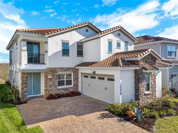 Stunning two-story home boasting a tile roof, stone accents, a spacious two-car garage and a brick-paved driveway at 13628 Abberwick Dr, Orlando, FL 32832