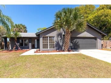 Charming single-story home with a lush lawn and mature landscaping, offering great curb appeal at 1404 Barcelona Ct, Winter Springs, FL 32708
