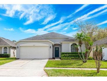 Charming single-story home with a well-maintained lawn and a two-car garage at 14410 Lake Underhill Rd, Orlando, FL 32828