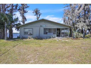 Charming lakefront home featuring a screened porch and surrounded by mature trees at 18951 Lake Pickett Rd, Orlando, FL 32820
