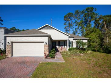 Charming single Gathering home with an attached two car garage and brick paved driveway and walkway at 2050 1St Ave, Deland, FL 32724