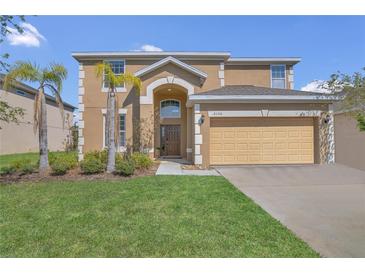 Two-story home featuring a two-car garage, well-maintained lawn, and front yard landscaping at 2136 Crofton Ave, Davenport, FL 33837