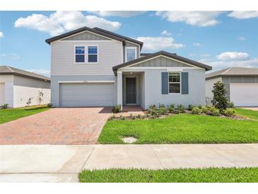 Charming two-story home with a well-manicured lawn and brick paver driveway at 2925 Wild Olive Dr, St Cloud, FL 34772