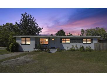 Charming single-story home with a well-maintained lawn and beautiful sunset sky at 5719 Meridian Way, Orlando, FL 32808