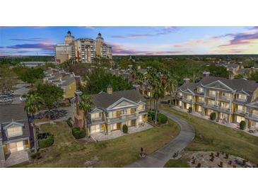 Beautiful exterior view of a two-story home with palm trees and a winding driveway, with a tall resort-style building in the background at 7512 Seven Eagles Way # 7512, Reunion, FL 34747