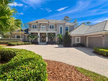 Stately two-story home featuring a circular driveway, manicured landscaping, and a tile roof at 1707 Stetson Ct, Longwood, FL 32779