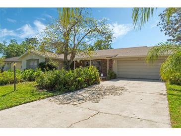 Charming single-story home featuring a lush front yard and a spacious driveway leading to an attached garage at 1873 Poinciana Rd, Winter Park, FL 32792