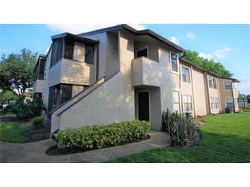 Exterior view of a two-story condo featuring neutral-colored walls, a screened-in porch, and well-maintained landscaping at 2936 Antique Oaks Cir # 71, Winter Park, FL 32792