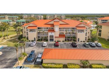 Stunning condo building features a bright orange tile roof and well-maintained landscaping at 445 Bouchelle Dr # 104, New Smyrna Beach, FL 32169