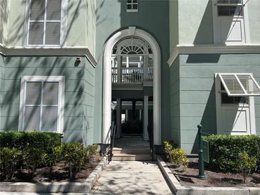 Elegant building entrance features an arched entryway, white trim, and manicured landscaping at 489 Water St # 489, Celebration, FL 34747