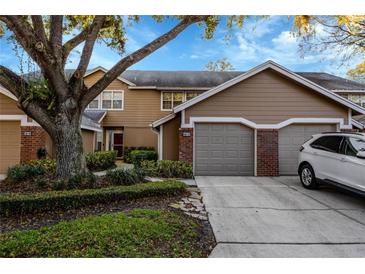 Exterior view of a brown two-story townhome with an attached garage and landscaped front yard at 638 Maple Oak Cir # 112, Altamonte Springs, FL 32701