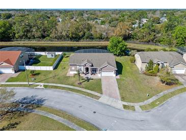 Stunning aerial view of a charming home with a screened-in pool and a serene waterfront backyard at 8706 Irmastone Way, Orlando, FL 32817