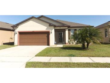 Charming single-story home with a well-maintained lawn and a two-car garage at 8878 Conway Rd, Polk City, FL 33868