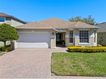 Charming single-story home with a well-maintained lawn, brick driveway, and a two-car garage at 9774 Nonacrest Dr, Orlando, FL 32832