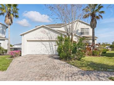 Charming home featuring a brick driveway, attached two-car garage, and well-maintained landscaping at 1207 Winding Cypress Ct, Kissimmee, FL 34746