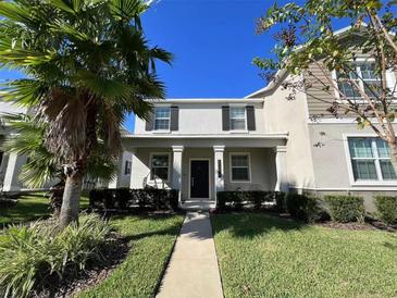 Charming two-story home with manicured lawn and welcoming front porch columns and black shutters at 10079 Memoir Ave, Winter Garden, FL 34787