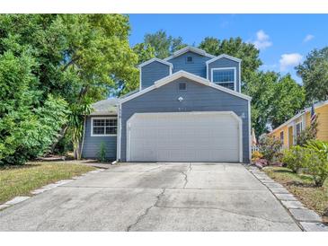Charming home with a two-car garage and driveway, surrounded by mature trees and landscaping at 119 Winterglen Dr Dr, Sanford, FL 32771