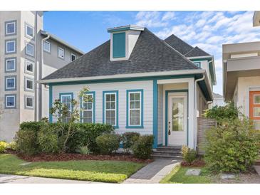 Charming home with a gray roof, blue trim, and well-maintained landscaping and a paver walkway at 14165 Moniz Ave, Orlando, FL 32827