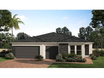 Charming single-story home featuring a modern design, three-car garage and neatly landscaped yard at 2073 Rock Maple Bnd, Kissimmee, FL 34746