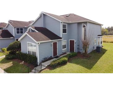 Charming two-story townhouse with brown roof, light blue siding, and a well-maintained lawn at 373 Caribbean Dr, Davenport, FL 33897