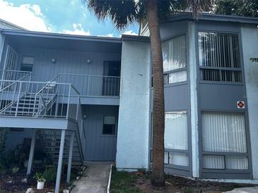 Two-story condominium building with exterior stairs and a mature palm tree at 4358 Aqua Vista Dr # G, Orlando, FL 32839